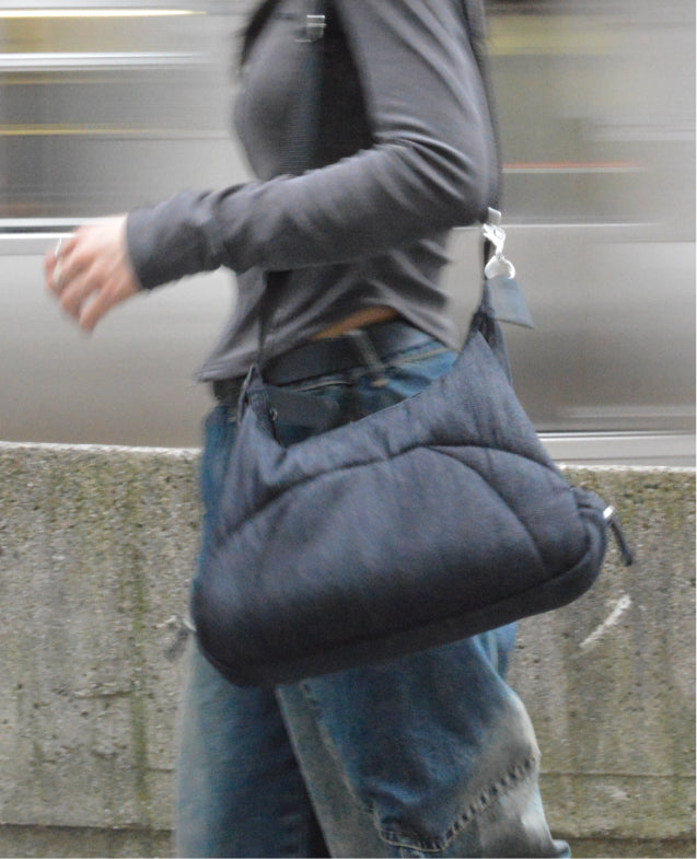 Motion-blurred person walking quickly past a passing train, Bottle Bag over one shoulder