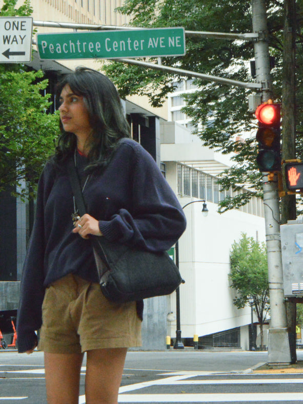 Woman waiting at a downtown Atlanta crosswalk wearing Bottle Bag over a sweater