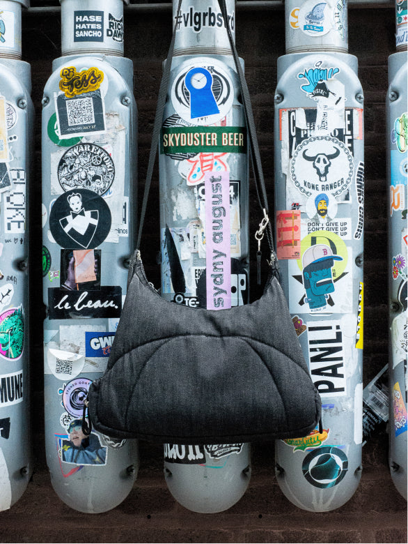 Bottle Bag hanging from a sticker-covered bollard