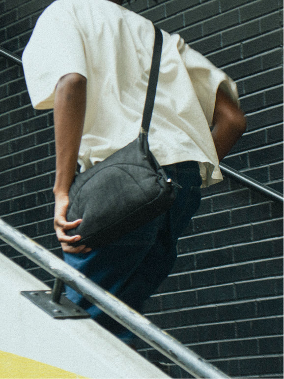 Close-up of Bottle Bag on a person's arm resting on a stairway railing