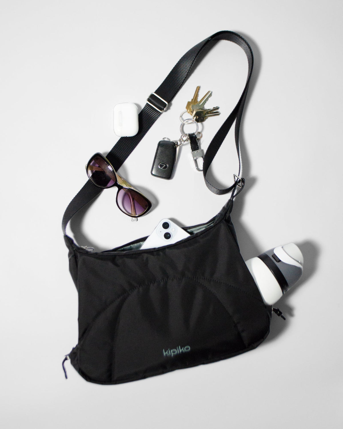 Bottle Bag in Black Crinkle Nylon / Dusty Blue, contents spilled out